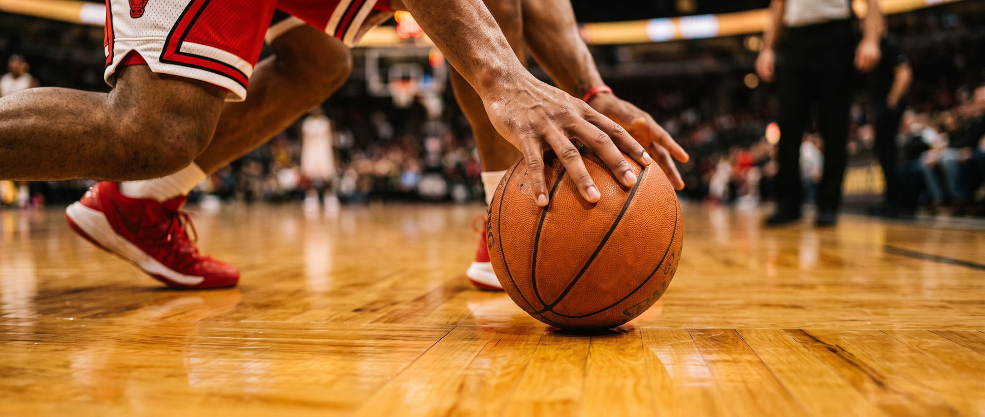 Una mano palleggia sul parquet